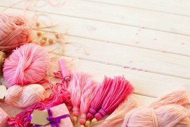 Pembe püsküllü. Beyaz ahşap arka plan. Kadın el sanatları. ,