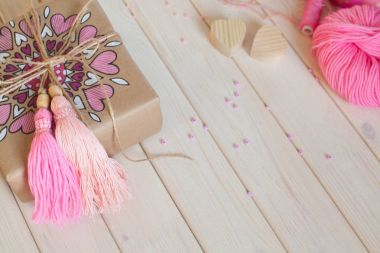 Pembe püsküllü. Beyaz ahşap arka plan. Kadın el sanatları. ,