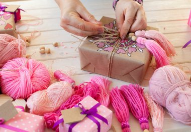 Pembe püsküllü. Beyaz ahşap arka plan. Kadın el sanatları. ,