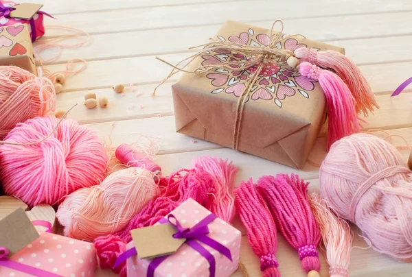 Pembe püsküllü. Beyaz ahşap arka plan. Kadın el sanatları. ,