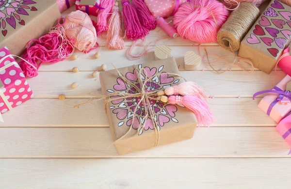 Pembe püsküllü. Beyaz ahşap arka plan. Kadın el sanatları. ,