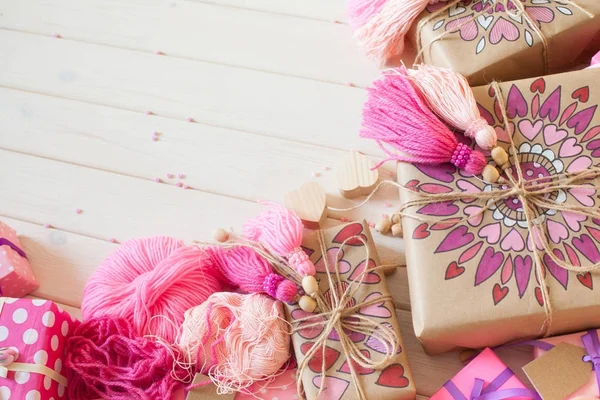 Pembe püsküllü. Beyaz ahşap arka plan. Kadın el sanatları. ,