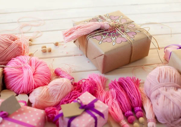 Pink tassels. Background of white wood. Women's handicrafts. The — Stock Photo, Image