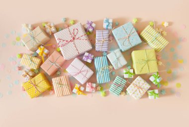 Bir sürü hediye ve pastel renkli konfeti. Pembe arkaplan.