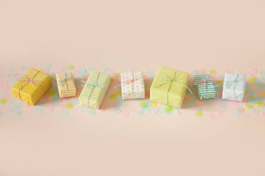 Bir sürü hediye ve pastel renkli konfeti. Pembe arkaplan.