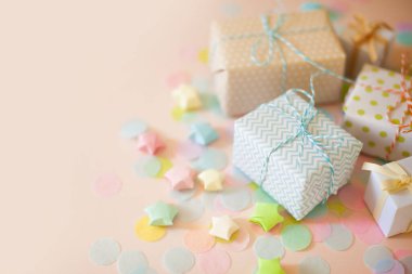 Hediye kutuları ve pastel renkli konfeti. Pembe arkaplan.