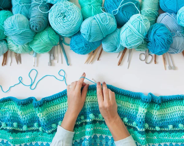 Women's hands are large. Woman crochets. Yarn of green, turquois — Stock Photo, Image