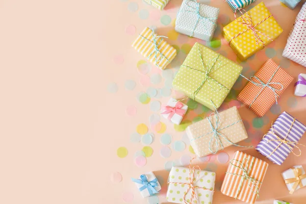 Muitos presentes e confetes de cor pastel. Fundo rosa . — Fotografia de Stock