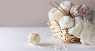 Sepette örgü örmek için beyaz ve bej iplik. Örgü iğneleri..