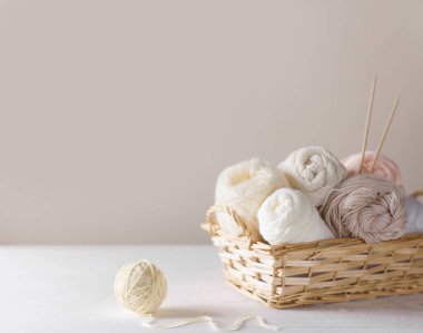 Sepette örgü örmek için beyaz ve bej iplik. Örgü iğneleri..