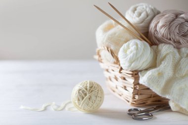 Sepette örgü örmek için beyaz ve bej iplik. Örgü iğneleri..