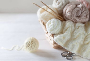 Sepette örgü örmek için beyaz ve bej iplik. Örgü iğneleri..