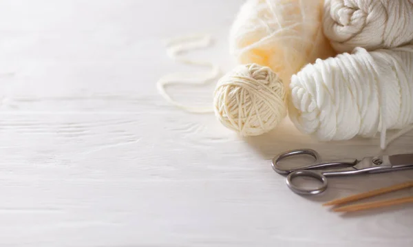 Knitting needles, white yarn, wooden background. — Stock Photo, Image