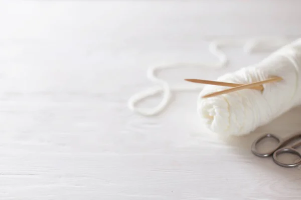 Agujas de tejer, hilo blanco, fondo de madera . — Foto de Stock