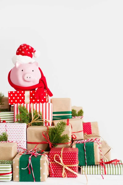 Sparschwein mit Weihnachtsmann-Hut. Weihnachtsgeschenkboxen. weißer Rücken — Stockfoto