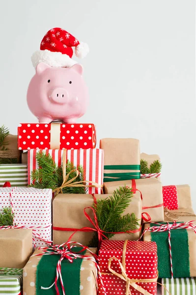 Sparschwein mit Weihnachtsmann-Hut. Weihnachtsgeschenkboxen. weißer Rücken — Stockfoto