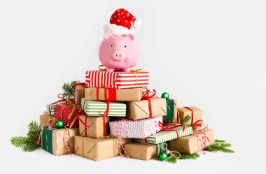 Piggy bank in santa claus hat. Christmas gift boxes. White backg