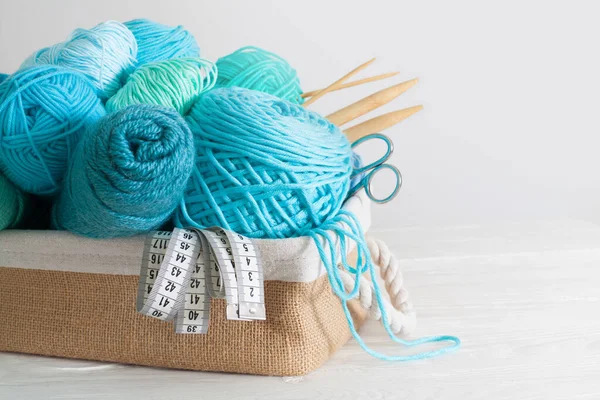 Blue and aquamarin yarn for knitting in a basket. Knitting need — Stock Photo, Image