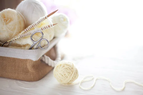 Wit en beige garen voor het breien in een mandje. breinaalden, — Stockfoto