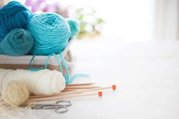 Blue and aquamarin yarn for knitting in a basket. Knitting need — Stock Photo, Image