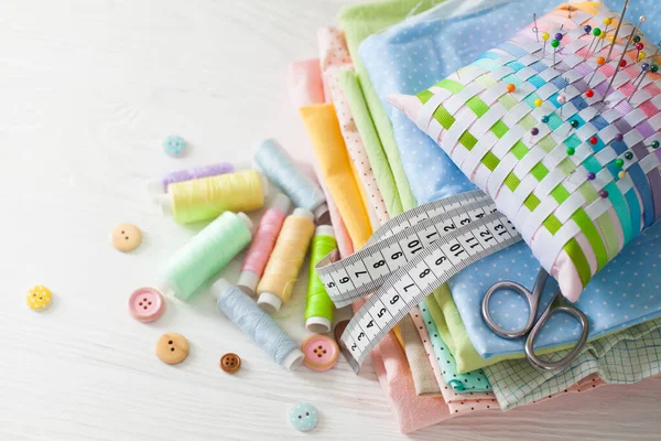 Caja de agujas, hilos y tejidos de algodón para coser. Fondo blanco —  Fotos de Stock