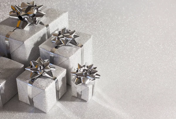 Silberne Weihnachtsgeschenke auf glitzerndem Hintergrund — Stockfoto