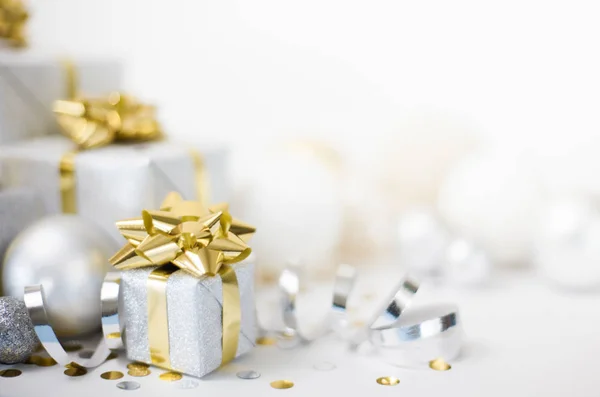 Χριστουγεννιάτικο πανό. Χριστουγεννιάτικο ασημένιο κουτί δώρου με χρυσά τόξα, λευκό βα — Φωτογραφία Αρχείου