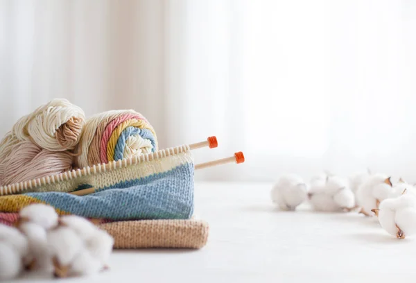 Agujas de punto y lana en colores pastel sobre bac blanco — Foto de Stock