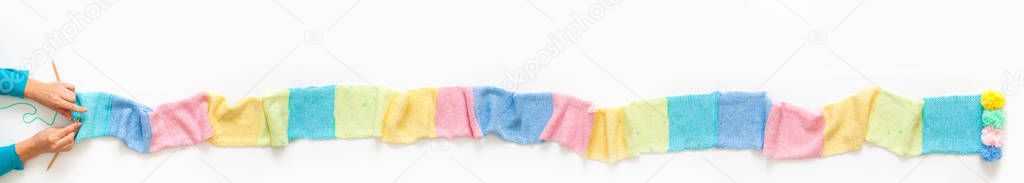 Knitted long scarf in pastel colors. Unicorn style. White backgr