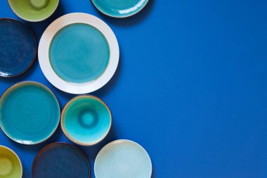 Mavi zemin üzerinde boş düz ve derin plakalar.