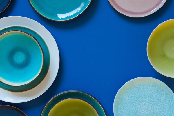 Empty flat and deep plates on a blue background.