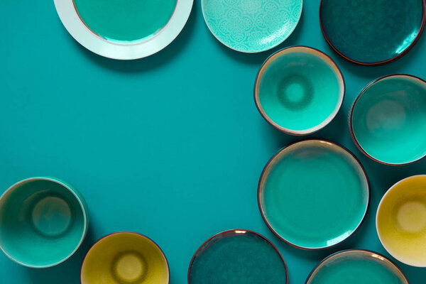 Empty flat and deep plates on a aquamarine background.