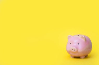 A pink piggy bank. Yellow background.