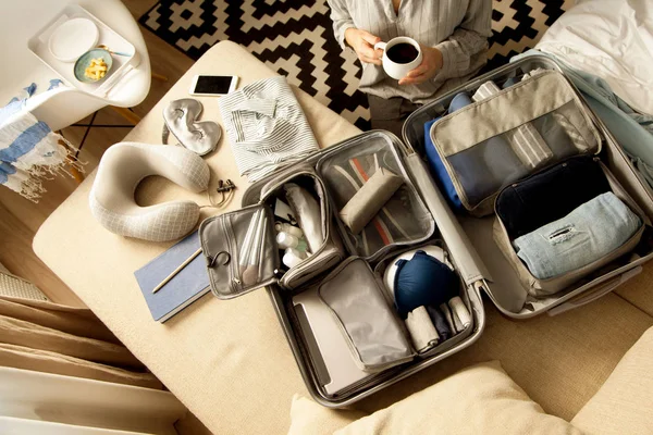 Öppen grå resväska med olika kläder packade för resa på — Stockfoto