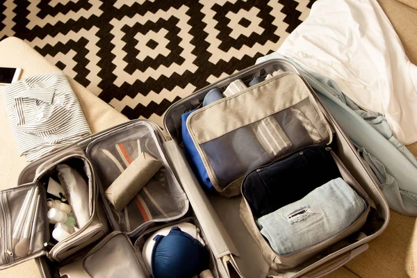 Ανοίξτε γκρι βαλίτσα με διαφορετικά ρούχα συσκευασμένα για το ταξίδι στο — Φωτογραφία Αρχείου