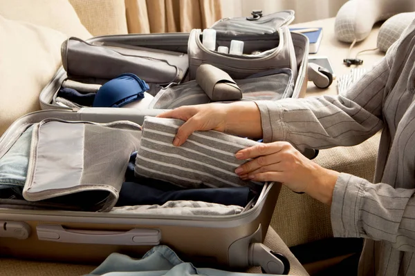 Otevřít šedý kufr s různými šaty zabalené na cestu na — Stock fotografie