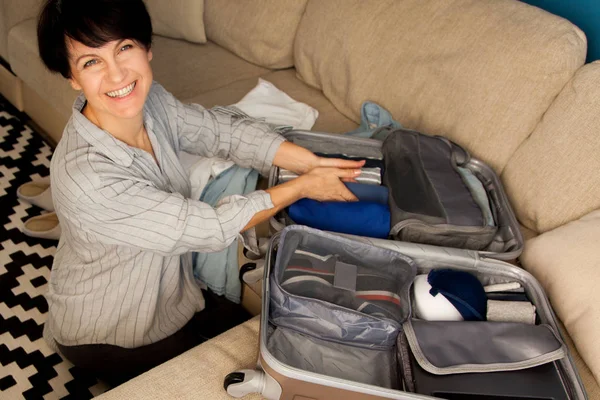 开放的灰色行李箱，装有不同的衣服，可于 — 图库照片