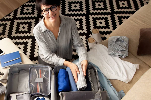 Відкрита сіра валіза з різним одягом, упакованим для подорожі — стокове фото
