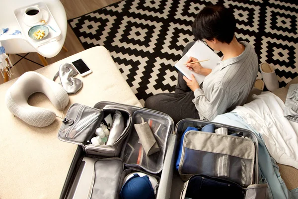 Valigia grigia aperta con diversi vestiti confezionati per il viaggio a — Foto Stock