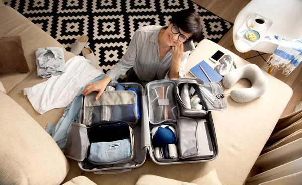 Valise ouverte grise avec différents vêtements emballés pour le voyage à — Photo