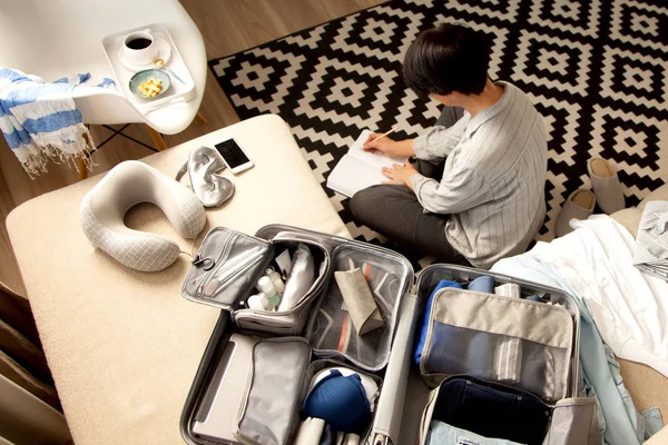 Maleta de color gris abierto con diferentes prendas de vestir embaladas para el viaje en — Foto de Stock