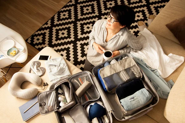Maleta de color gris abierto con diferentes prendas de vestir embaladas para el viaje en — Foto de Stock