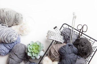 Yarn for knitting neutral colors. Accessories for knitting. Centimeter tape, scissors, knitting needles. Started knitted fabric. clipart