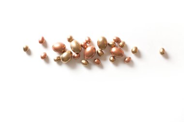 Altın bakır ve siyah sanatın çok renkli ve küçük yumurtalarının üst görüntüsü beyaz izole bir zemin üzerinde güzel bir şekilde uzanır. Paskalya kutlamaları konsepti. Reklam alanı