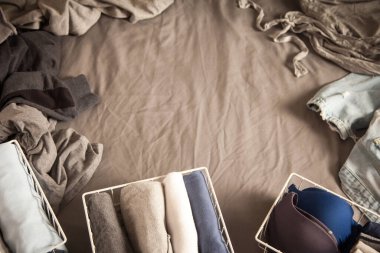 Gardıropta sipariş verin. Kıyafetler düzgünce katlanmış. Gri arka plan. Yatak odası, düzenleme, dağınıklık.