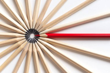 Kırmızı kalemin üst görüntüsü beyaz arka planda duran gri kalemler çemberine düşme eğilimindedir. Ofis ekibindeki göze çarpan çalışanın uygunsuz konsepti. Eksantrik konsept