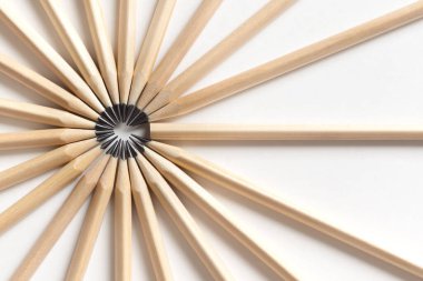 Ahşap şekillendirme çemberinden yapılmış kalemlerin üst görüntüsü beyaz bir arka planda, sivri uçlu bir kalemin yanında yatıyor. Bir takım ya da takımda acemi kavramı. Tecrübesiz çalışan