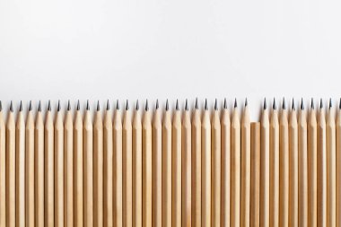 Beyaz arka planda düzgünce sivriltilmiş tahta kalemler ve bir kalem eksik. Değersiz bir çalışan ya da aile üyesi kavramı. Reklam alanı