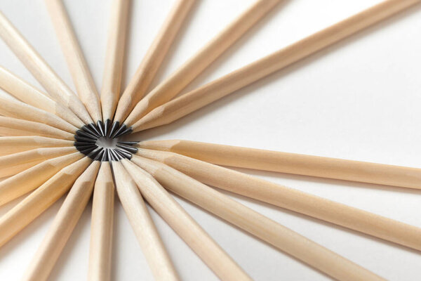 Top view of pencils made of wood lie on a white surface forming an open circle. The concept of free space in the team. Vacancy in friendly team. Advertising space