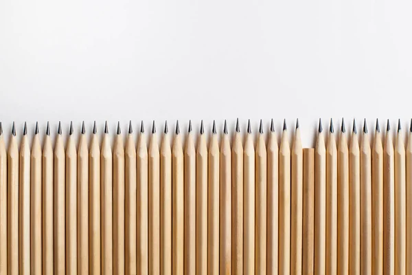 用木头做的精雕细琢的铅笔 一排缺了一支铅笔 放在白色的背景上 不合适的员工或家庭成员的概念 广告空间 — 图库照片